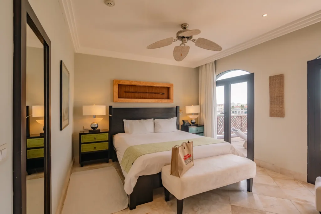 A bedroom with a large bed and a ceiling fan