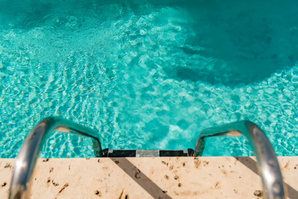 an aerial view of a swimming pool with a metal handrail
