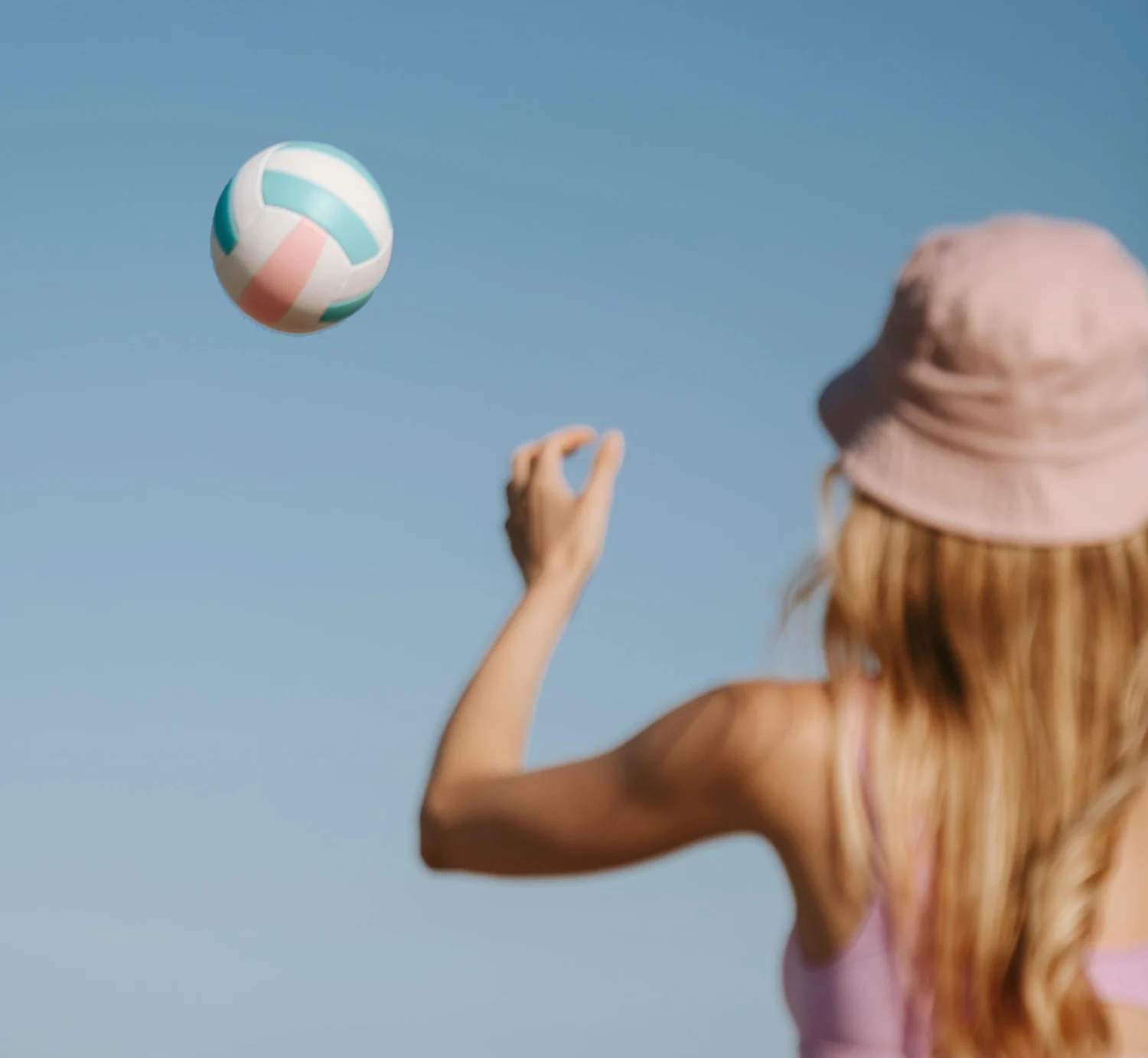 a woman in a pink top is playing with a ball