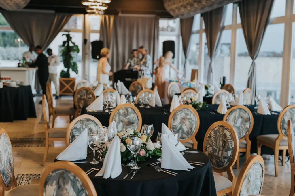 a dining room filled with lots of tables covered in black and white cloths
