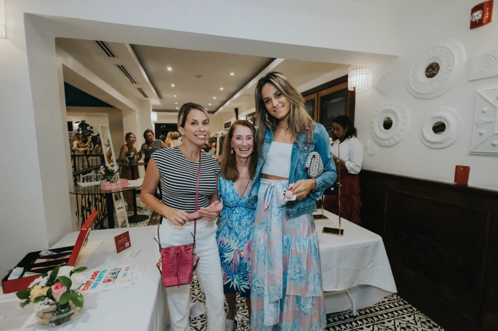 a group of women standing next to each other near a table