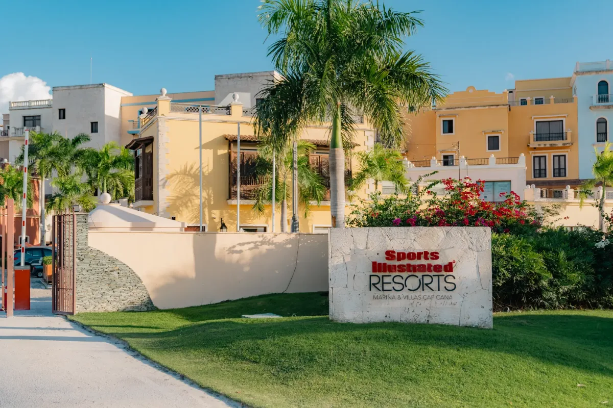 a sign for a resort with palm trees in the background